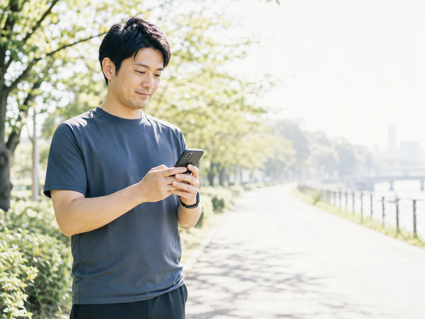 公園でスマートフォンを開き、新たな気持ちでアプリを始めようとする30代男性